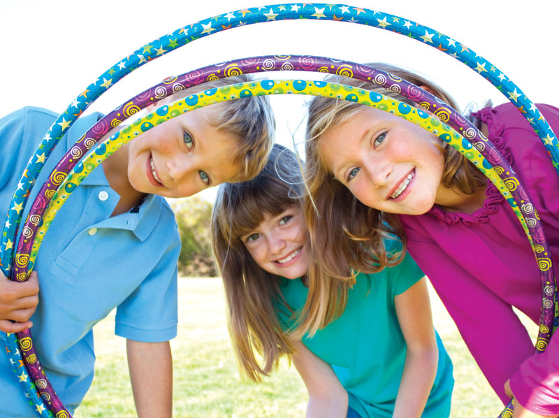 Two girls and a boy playing with hula hoops.